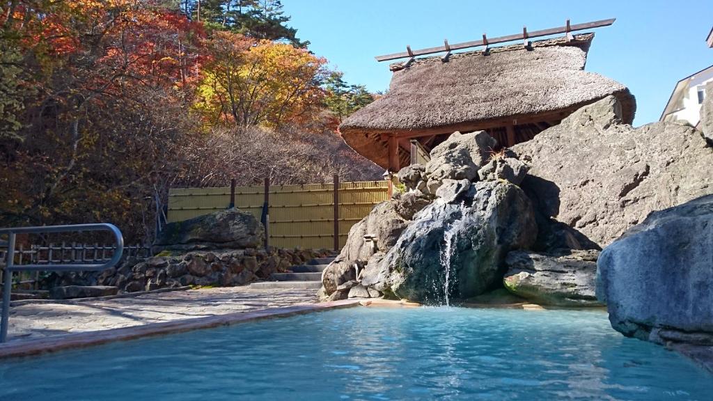- une piscine avec une cascade dans l'arrière-cour dans l'établissement Ryokan Tamagoyu, à Machi-niwasaka