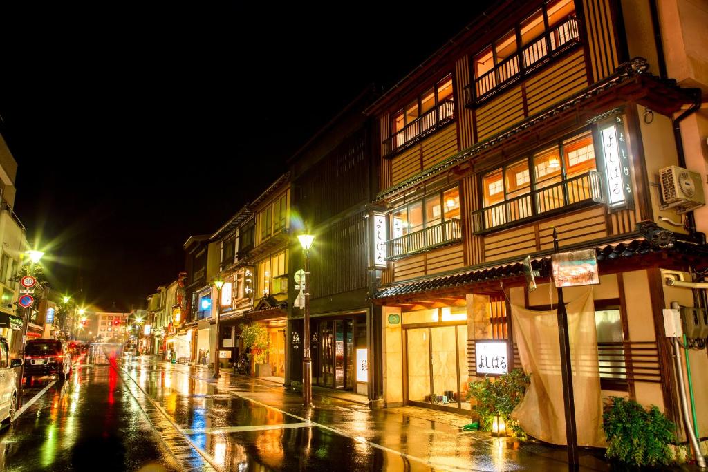 une rue de la ville la nuit avec des bâtiments et des lumières dans l'établissement Yoshiharu, à Toyooka