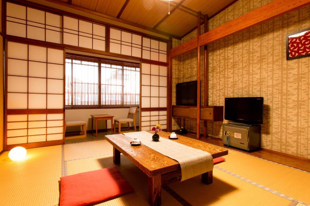 Cette chambre dispose d'une table et d'une télévision. dans l'établissement Yoshiharu, à Toyooka