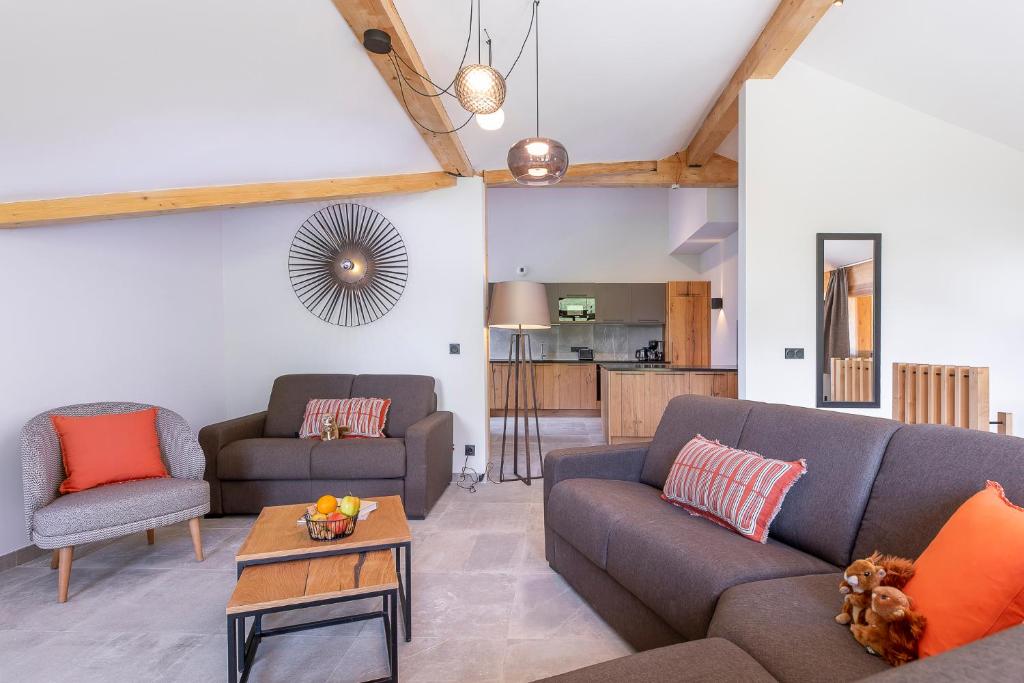 un salon avec deux canapés et une table dans l'établissement La Cour aux Ecureuils, à Peisey-Nancroix