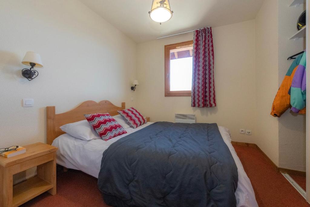 une chambre avec un lit et une fenêtre dans l'établissement Résidence Goélia Les Alpages du Corbier, à Villarembert