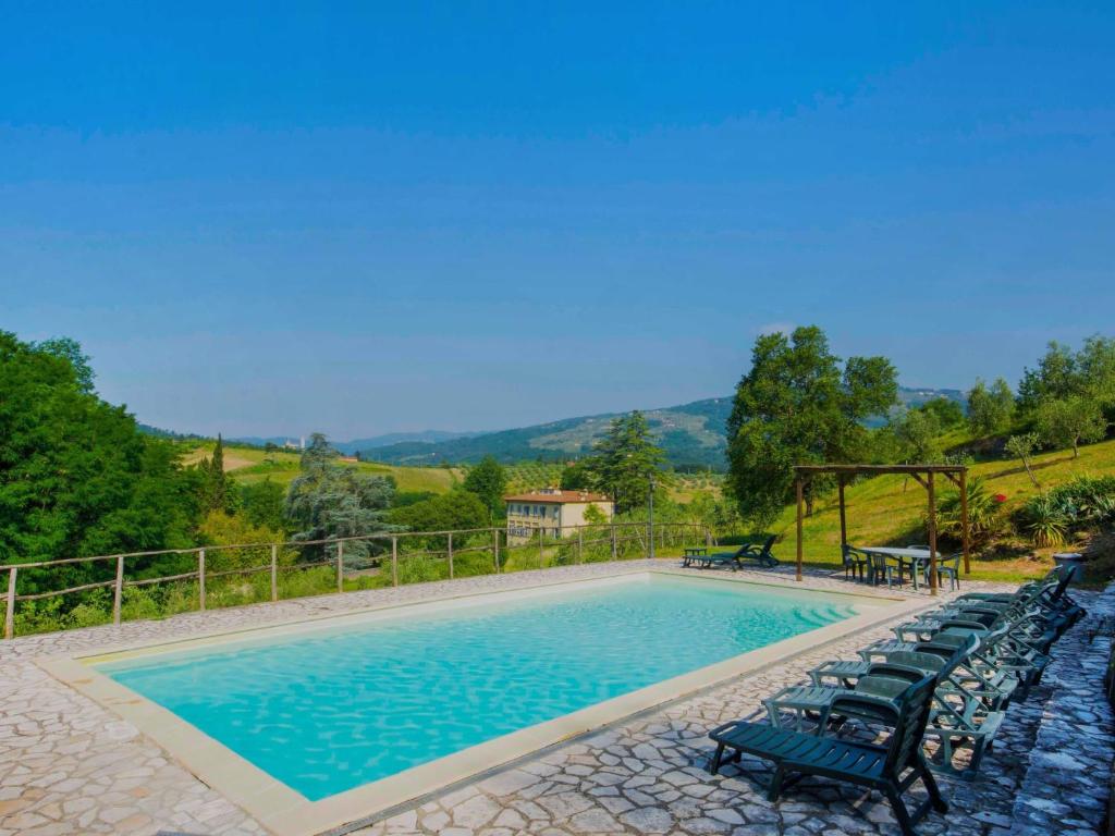 une piscine avec un tas de chaises autour dans l'établissement Villa Nicoletta by Interhome, à Serravalle Pistoiese
