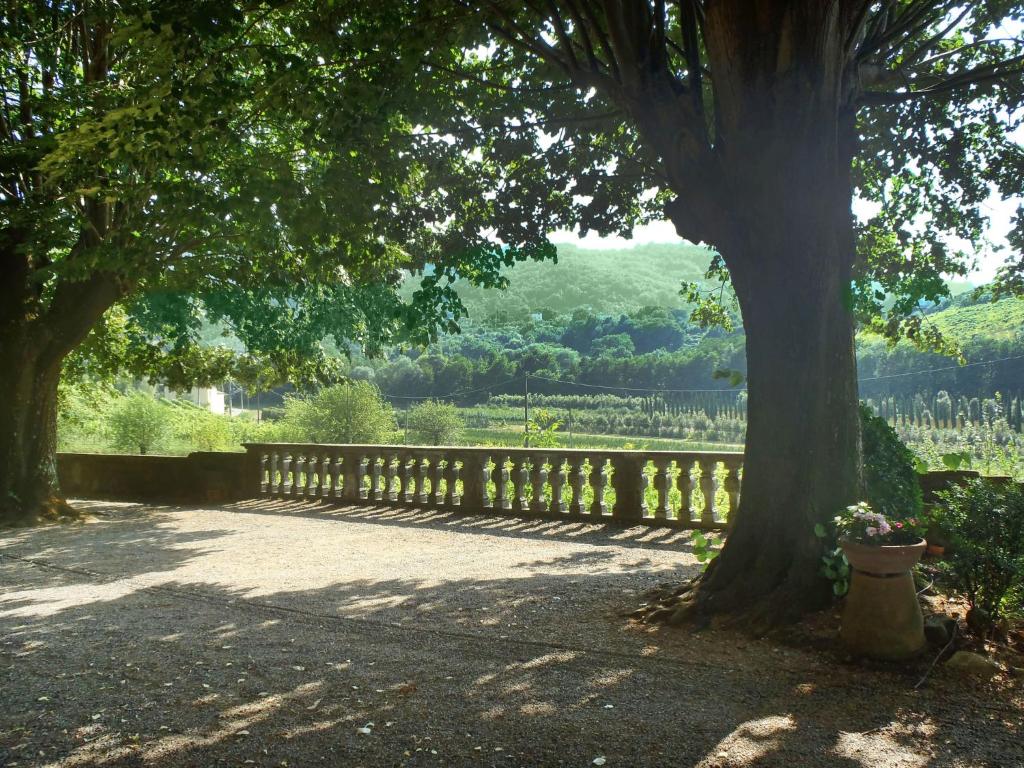 une clôture en bois avec un arbre à côté dans l'établissement Villa Nicoletta by Interhome, à Serravalle Pistoiese