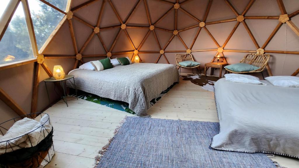 - une chambre avec un lit et deux chaises dans une yourte dans l'établissement Sottu E Stelle, à Albitreccia
