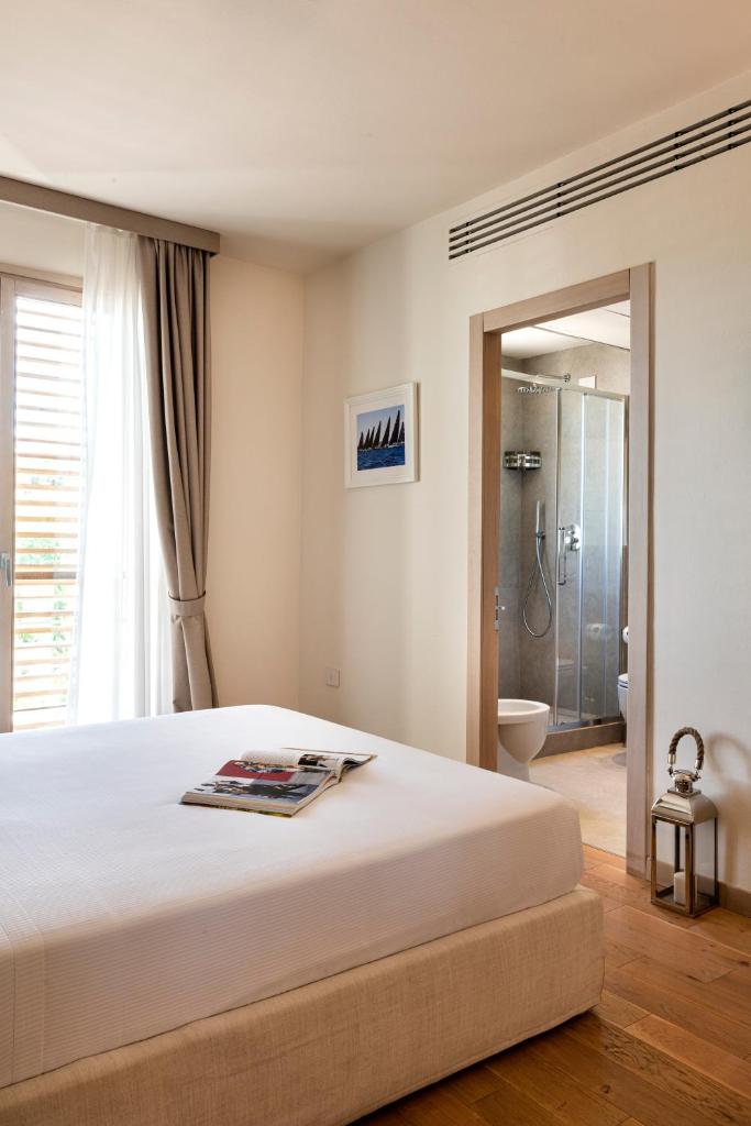 une chambre avec un lit et une salle de bain avec douche dans l'établissement Marina di Scarlino Resort, à Puntone di Scarlino