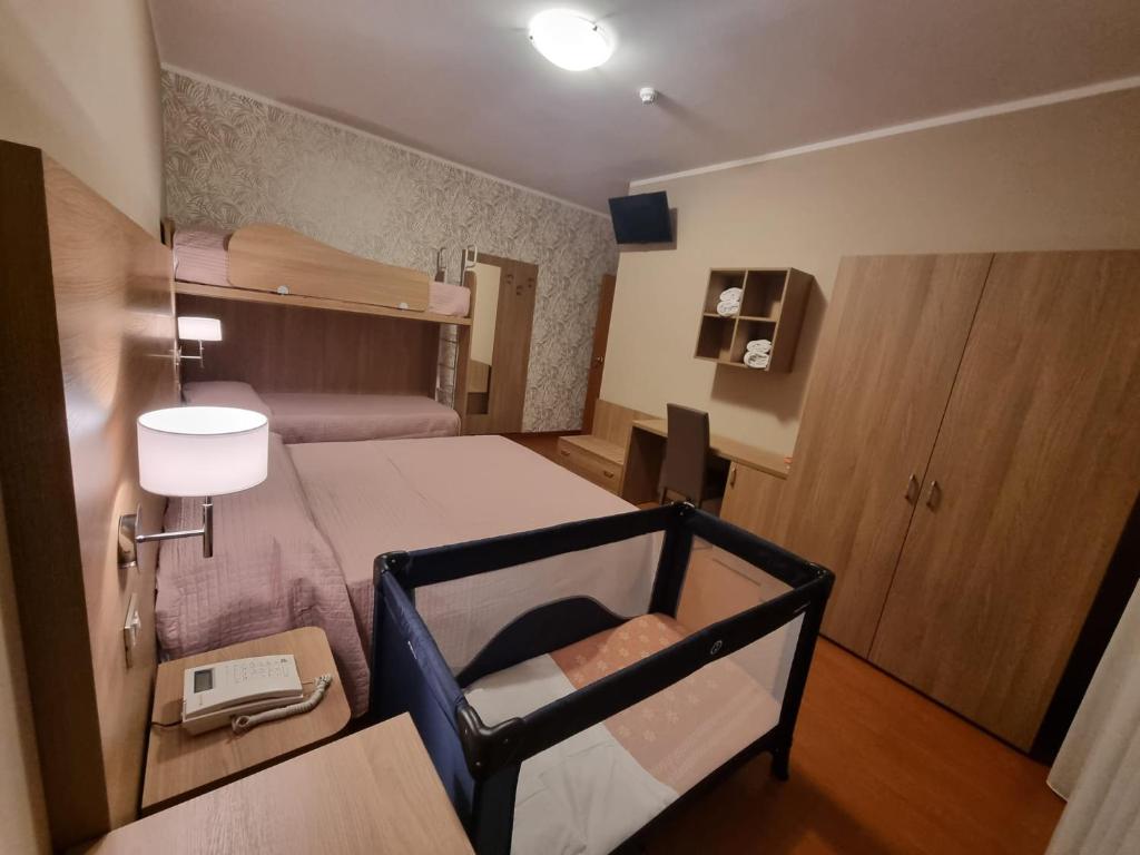 Cette petite chambre comprend un lit et un bureau avec un téléphone. dans l'établissement Hotel Fornaci, à Peschiera del Garda