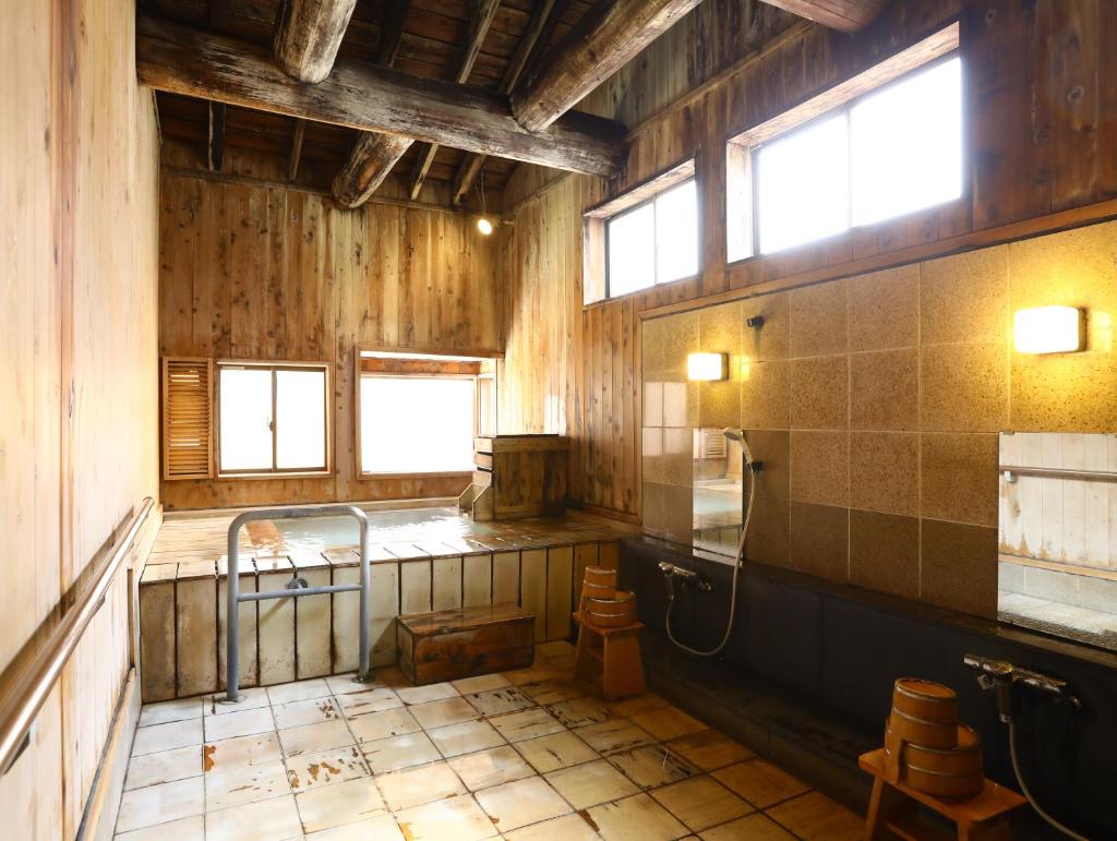- une salle de bains ancienne avec lavabo et toilettes dans l'établissement Manza Onsen Nisshinkan, à Tsumagoi
