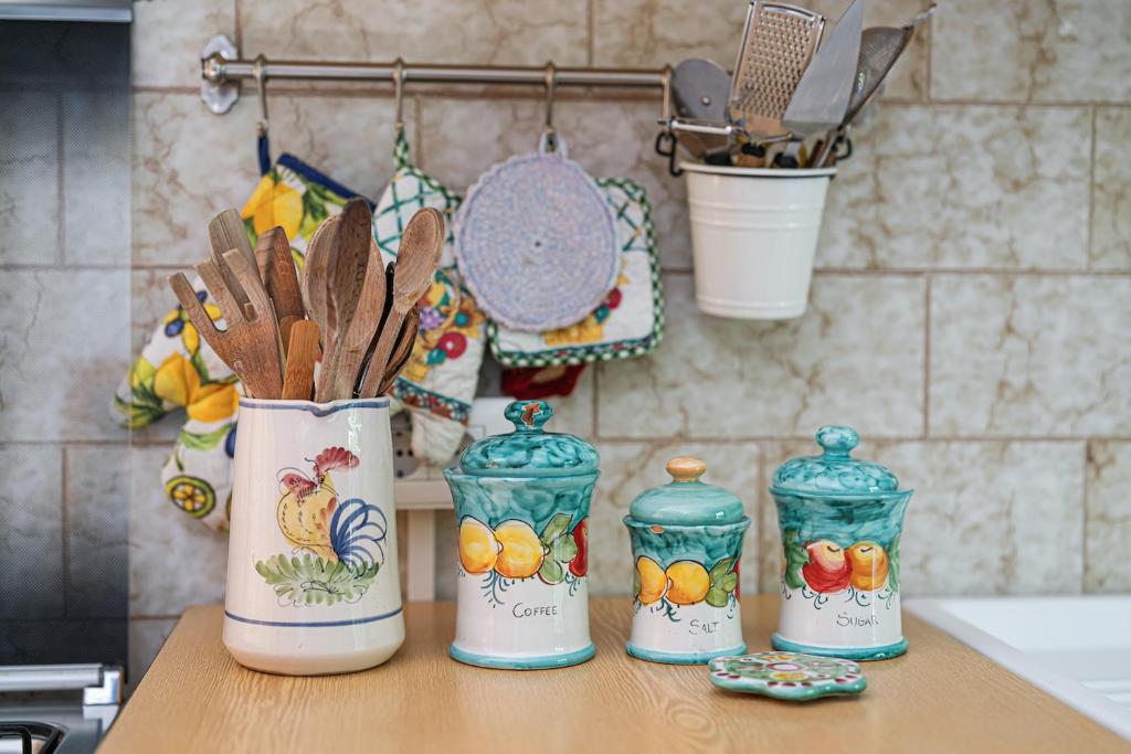 un groupe de quatre conteneurs sur un comptoir avec ustensiles dans l'établissement Villa Aurora, à Vico Equense