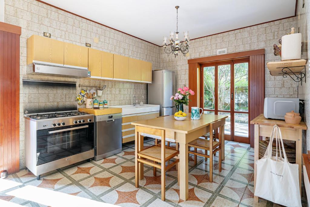 une cuisine avec une table et une cuisinière four supérieur dans l'établissement Villa Aurora, à Vico Equense