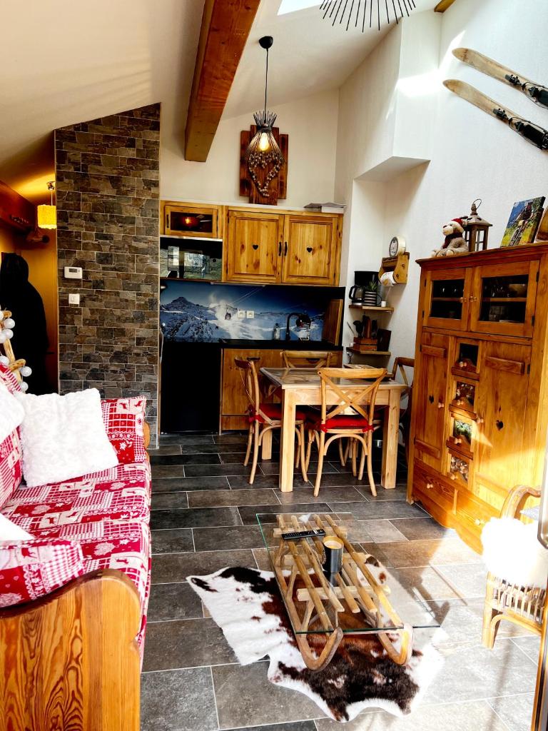 un salon avec une table et une cuisine dans l'établissement Appartement Schuss II vue montagne au pied des pistes, à Flumet