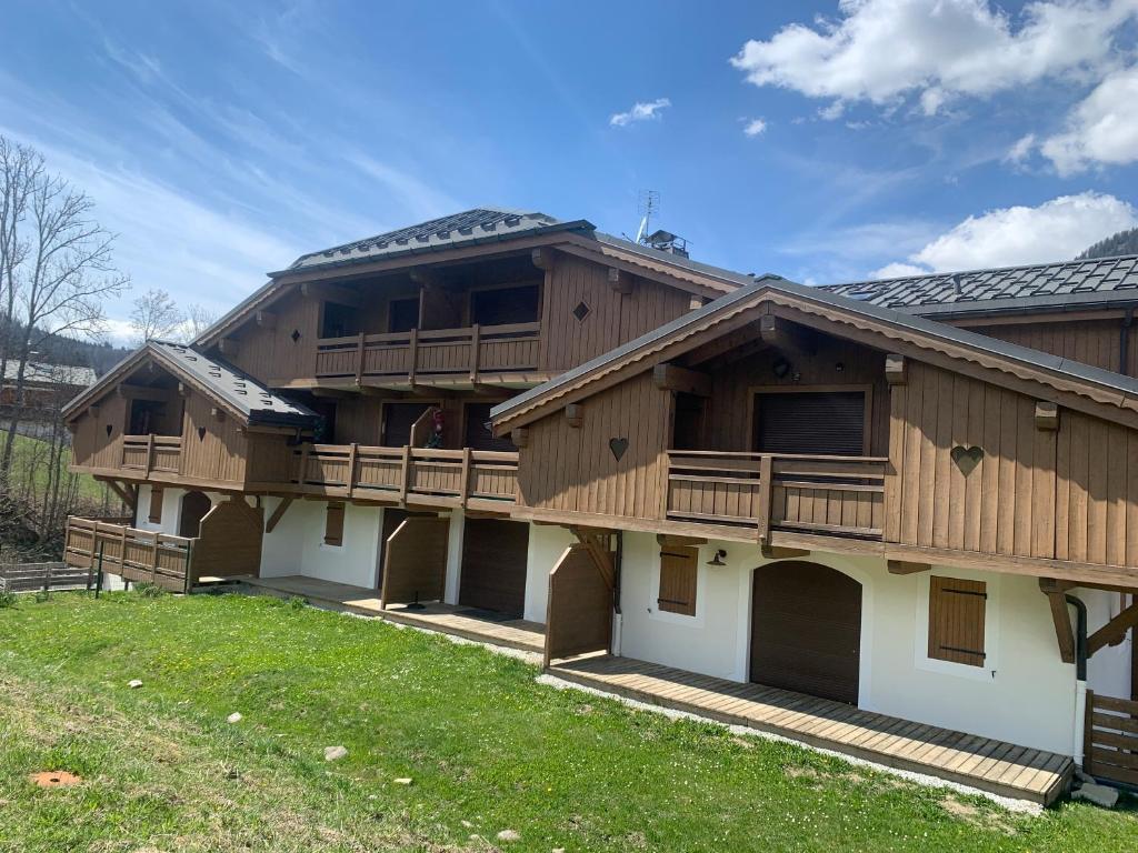 une grande maison avec une terrasse et une cour dans l'établissement Appartement Schuss II vue montagne au pied des pistes, à Flumet