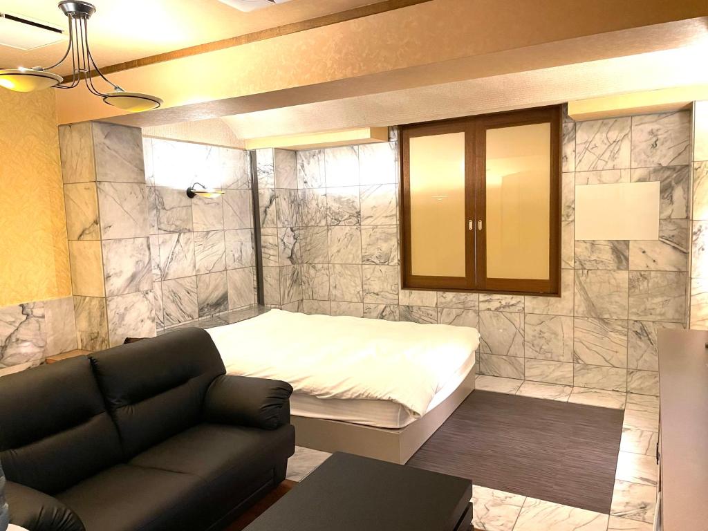 un salon avec un lit et un canapé dans l'établissement Hotel Ai - coupls hotel, à Azumino