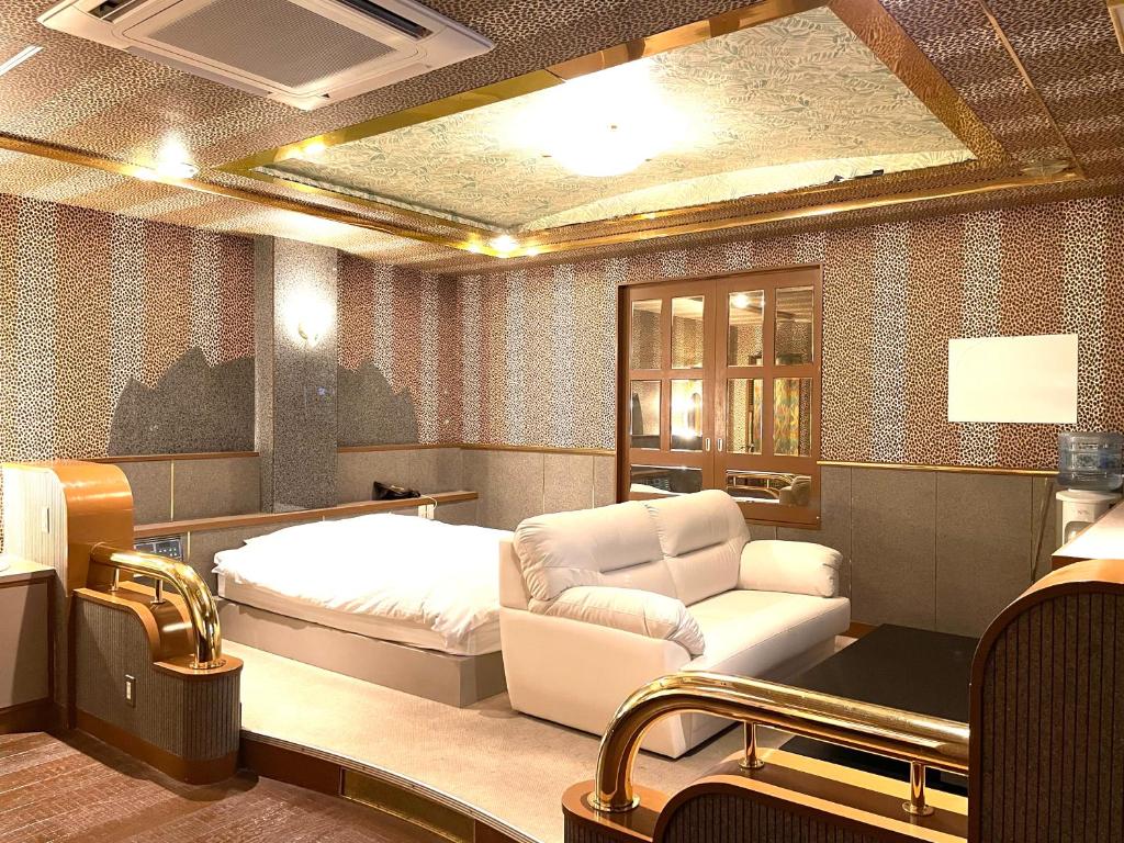 une chambre avec un lit, un canapé et une chaise dans l'établissement Hotel Ai - coupls hotel, à Azumino