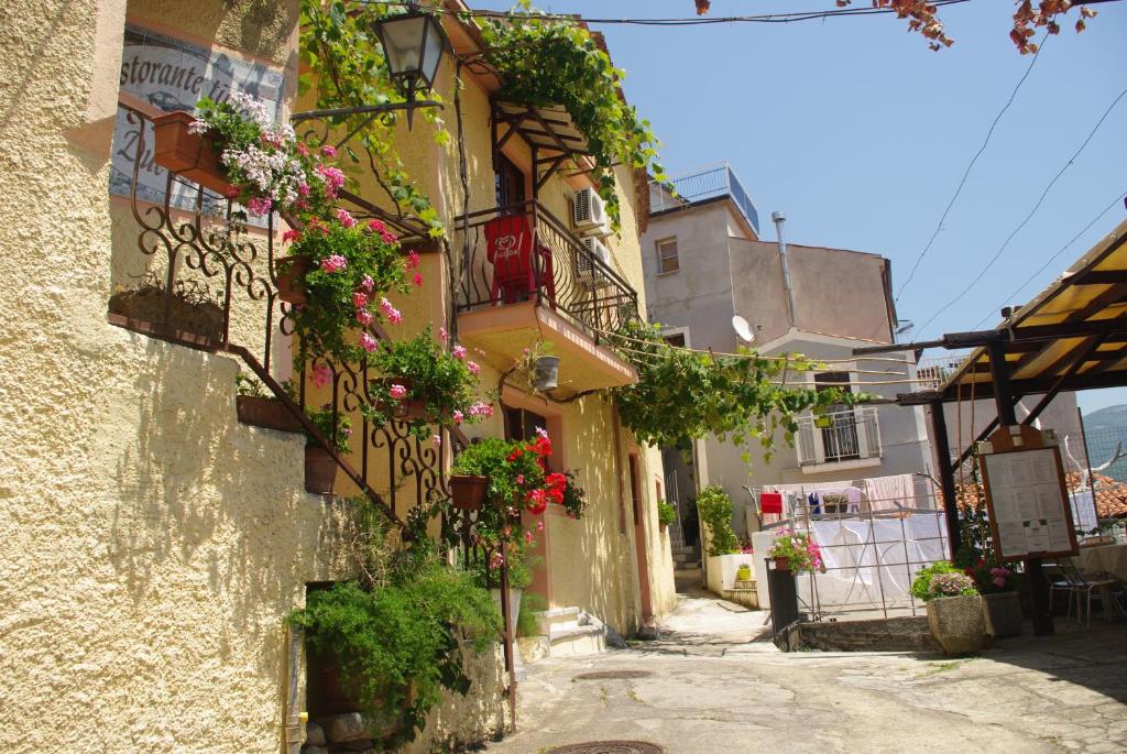 Une allée avec des fleurs sur le côté d'un bâtiment dans l'établissement Le Due Lanterne, à Aieta