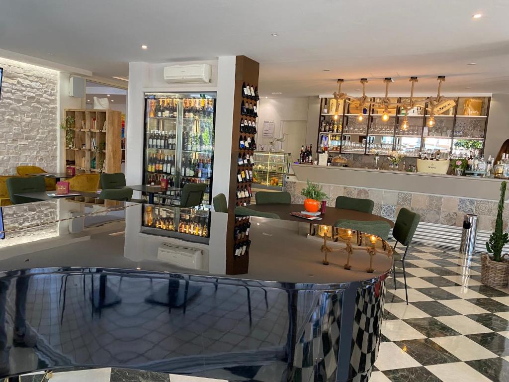 un bar dans un restaurant avec un sol en damier dans l'établissement Hotel Croce Di Malta, à Lignano Sabbiadoro