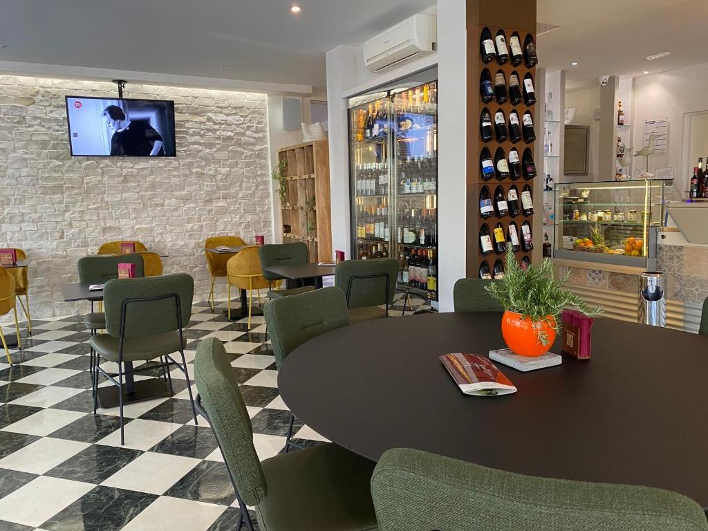 un restaurant avec une table, des chaises et une télévision dans l'établissement Hotel Croce Di Malta, à Lignano Sabbiadoro