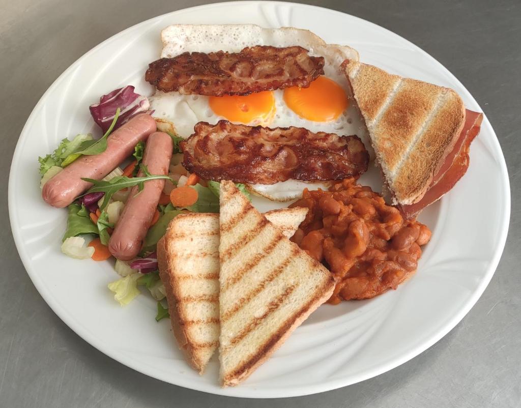 une assiette de nourriture avec des œufs, de la viande, du pain grillé et des haricots dans l'établissement Hotel Losanna Cervia, à Cervia 105 autres photos