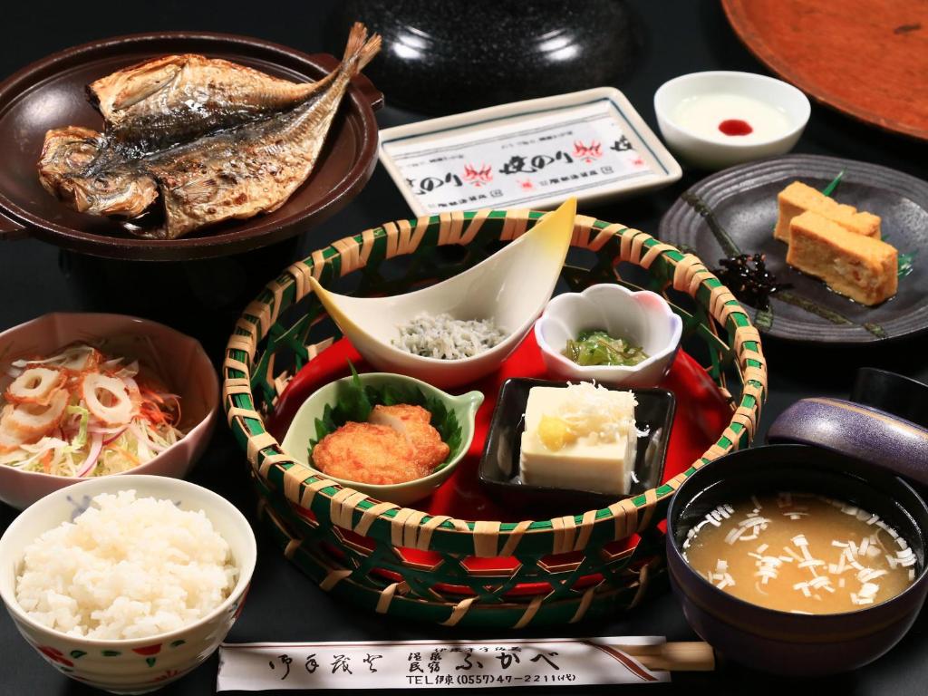 une table recouverte de différents types de nourriture dans des bols dans l'établissement ふかべ, à Itō