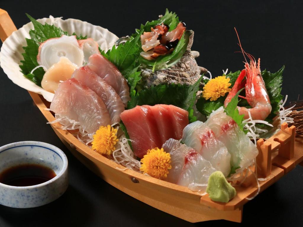 une assiette de nourriture avec des sushis et d'autres aliments dans l'établissement ふかべ, à Itō