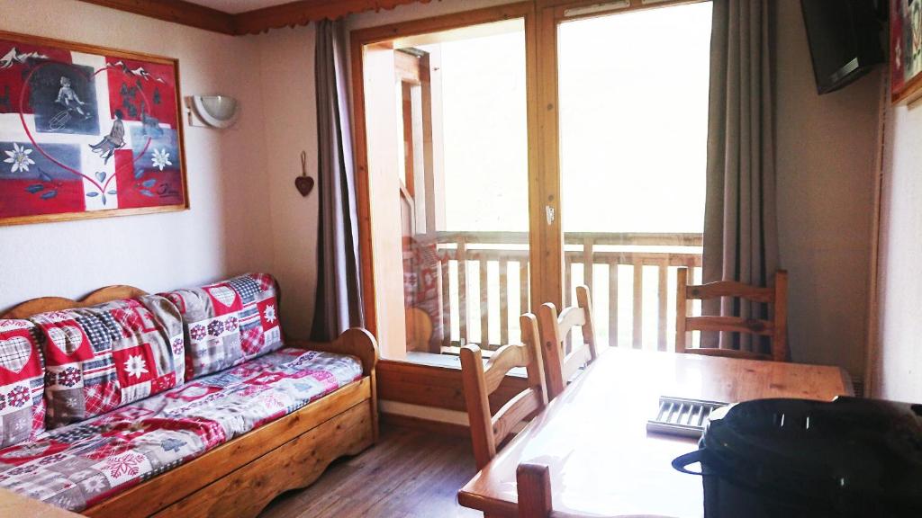 d'un salon avec un canapé et une table ainsi que d'un balcon. dans l'établissement Résidence Valmonts A, Les Ménuires, appartement 2 pièces, aux Menuires