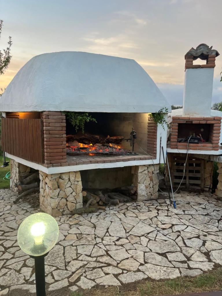 un grand barbecue extérieur avec cheminée dans l'établissement Hotel Baia Cea, à Bari Sardo