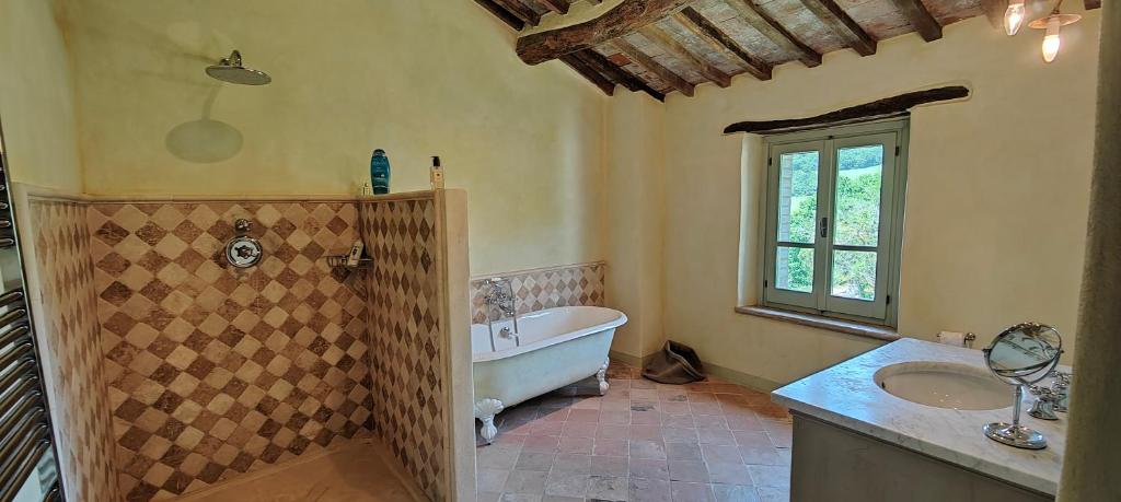 une grande salle de bain avec une baignoire et un lavabo dans l'établissement Infinity pool villa - Fonte Piccola, à Città di Castello