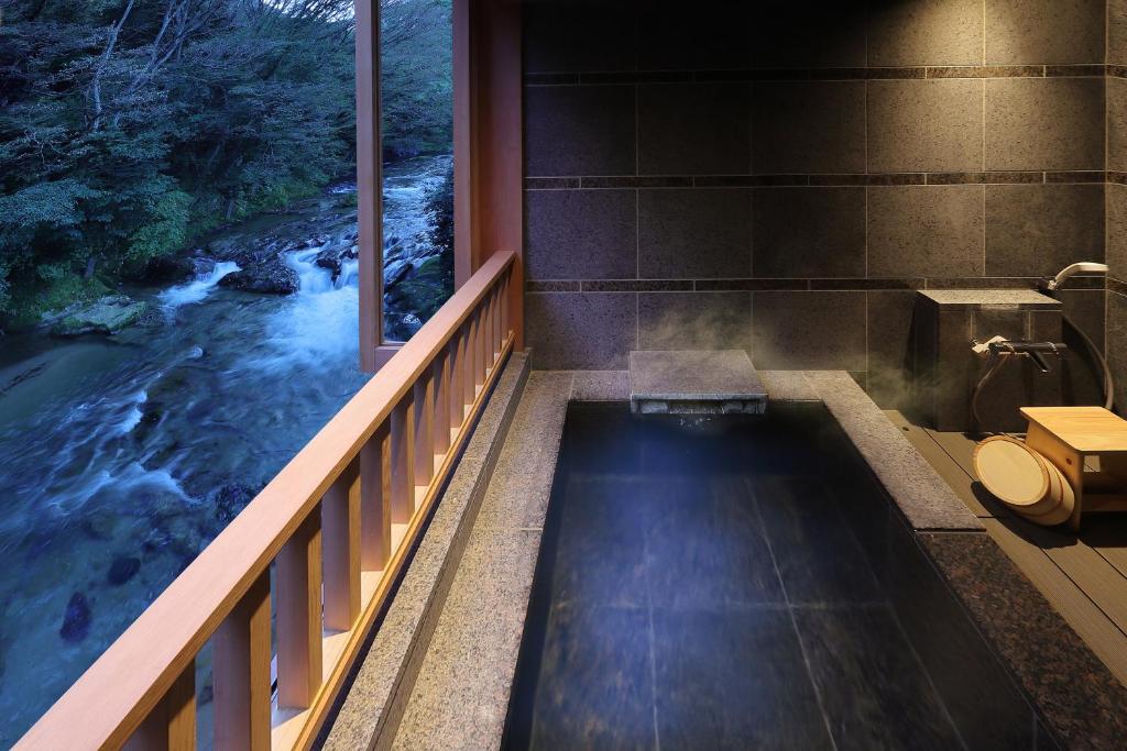 La salle de bains est pourvue d'une baignoire profonde et offre une vue sur la rivière. dans l'établissement Moritaya, à Koriyama