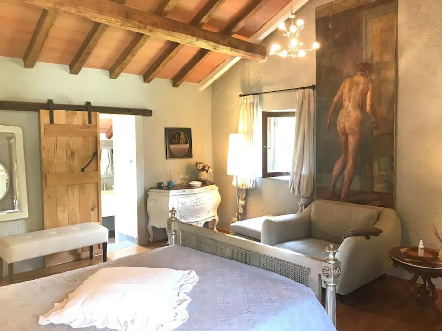 une chambre avec un lit et un tableau au mur dans l'établissement Casale del Pozzo-Villa with pool - Fosdinovo in the borgo of Pulica, à Tendola