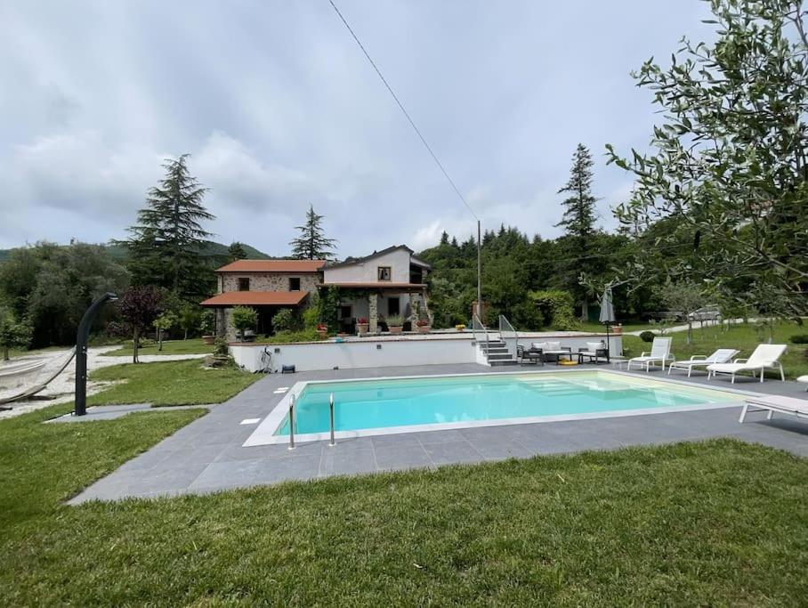 une piscine devant une maison dans l'établissement Casale del Pozzo-Villa with pool - Fosdinovo in the borgo of Pulica, à Tendola