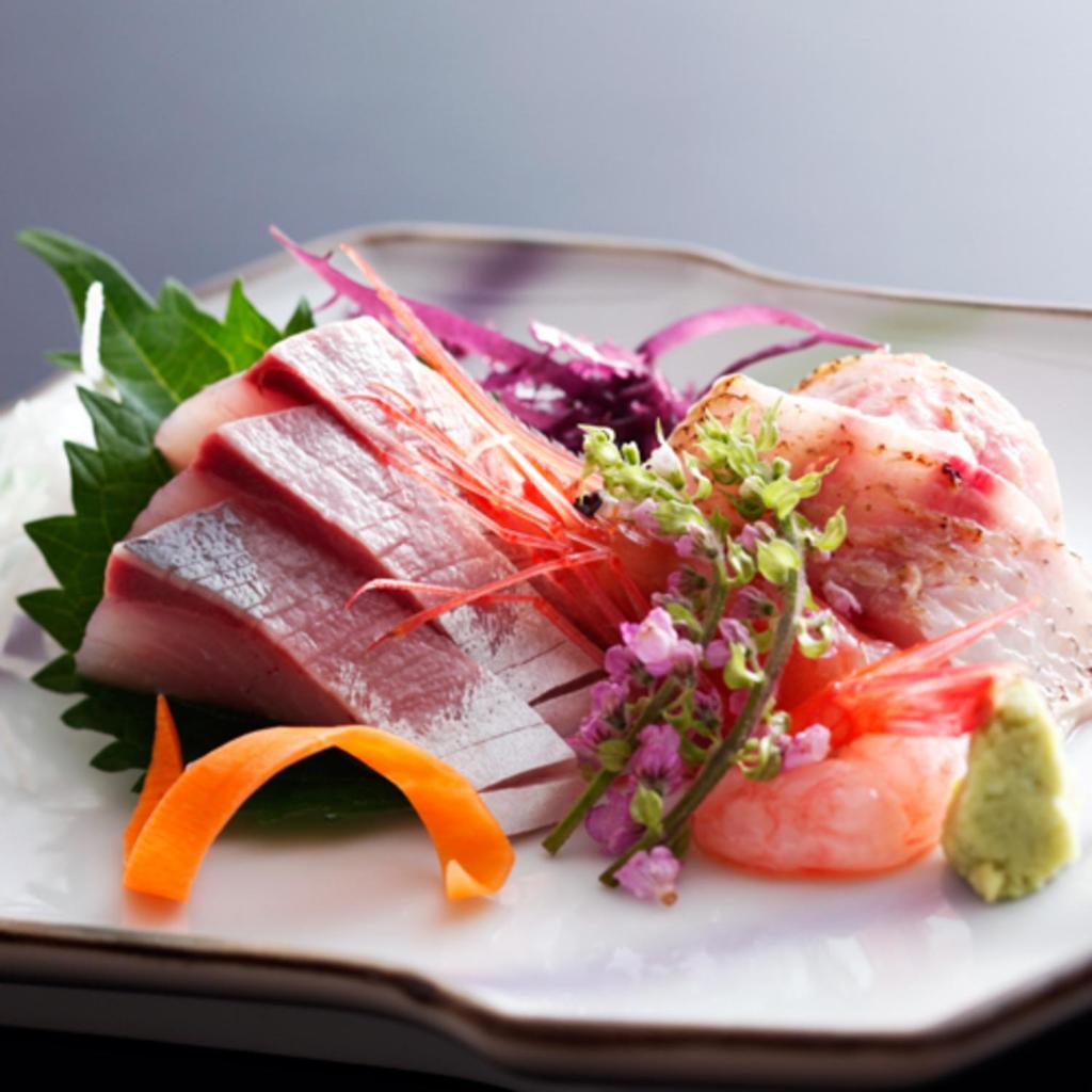 une assiette de nourriture contenant du poisson et des légumes dans l'établissement Houshoutei, à Kaga