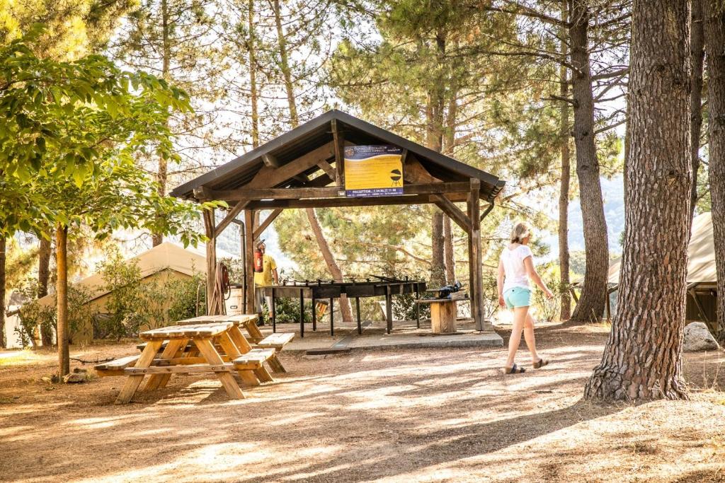 une femme debout devant un abri de pique-nique dans l'établissement Camping Olva - Maeva, à Sartène