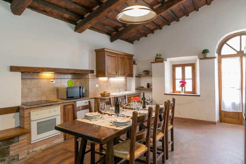 une cuisine avec une table et des chaises dans une cuisine dans l'établissement Villa Adelmo, à Pomarance