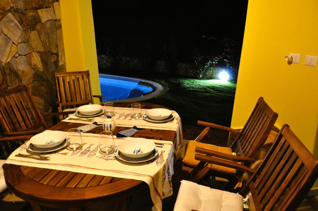 une table et des chaises avec une table et une piscine dans l'établissement Villa Nadia con piscina privata Budoni, à Tanaunella