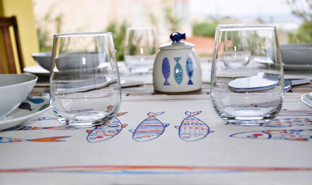 une table avec trois verres à vin en haut dans l'établissement Villa Nadia con piscina privata Budoni, à Tanaunella