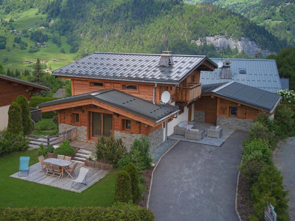une vue aérienne d'une maison en bois avec un patio dans l'établissement chalet l'Orignal 145m2, 10pers, pied de piste,SPA, à Notre-Dame-de-Bellecombe