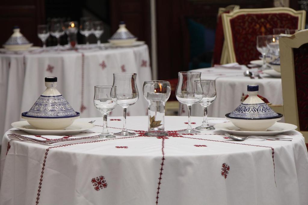 - une table avec des verres à vin et des vases dans l'établissement Riad Les Remparts De Fès, à Fès