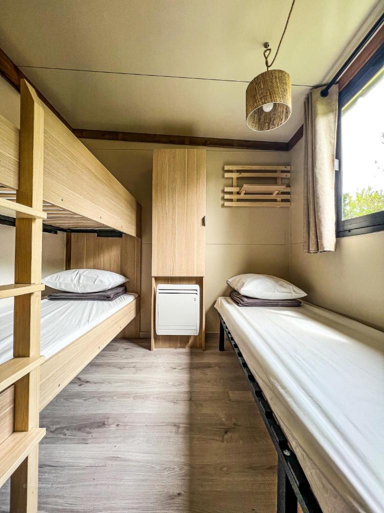 une chambre avec deux lits superposés et une fenêtre dans l'établissement Camping Onlycamp le Champ d'été, à Reyssouze 37 autres photos