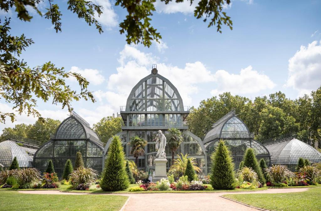 une serre avec une statue au milieu d'un jardin dans l'établissement CityKamp Lyon, à Dardilly