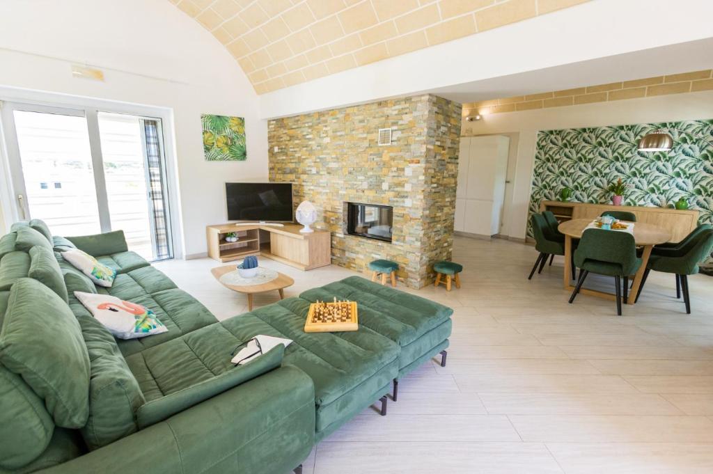 un salon avec un canapé vert et une table dans l'établissement Villa Bella Ostuni by Villa Plus, à Ostuni