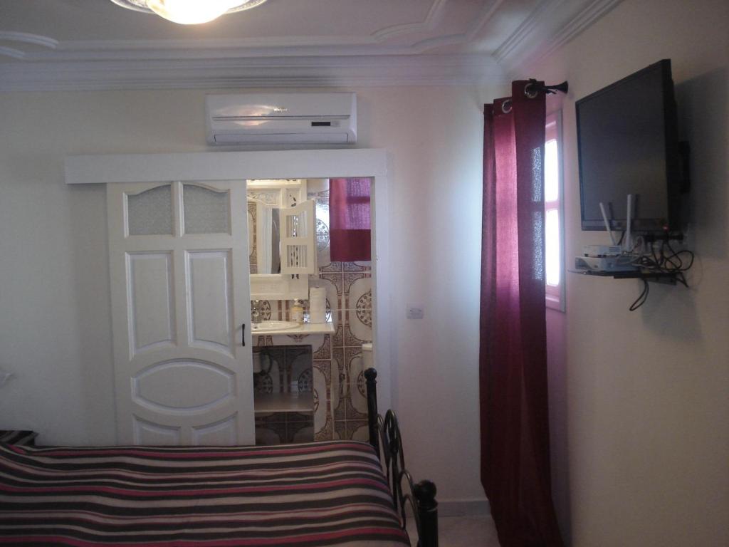 Cette chambre dispose d'un lit et d'une porte avec fenêtre. dans l'établissement Riad Marlinea, à Sale