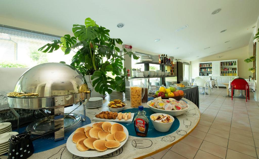 - une table avec des assiettes de nourriture dans la cuisine dans l'établissement Nice Hotel Bibione, à Bibione