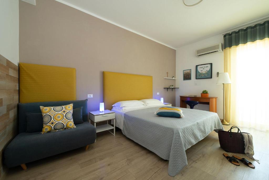 une chambre avec un lit et une chaise dedans dans l'établissement Nice Hotel Bibione, à Bibione 68 autres photos