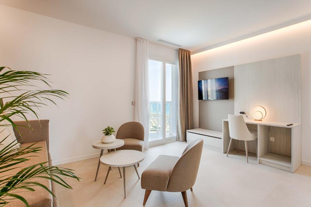 un salon avec une table et des chaises dans l'établissement Hotel Mirafiori, à Lido di Jesolo