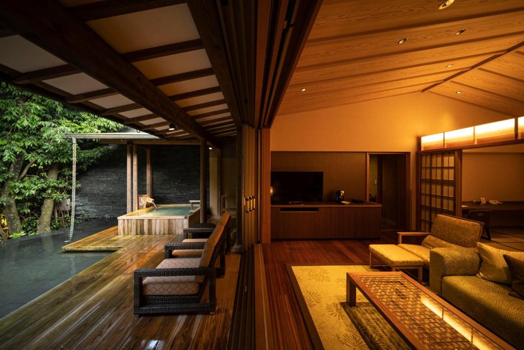 un salon avec un canapé et une télévision dans l'établissement ABBA Resorts Izu - Zagyosoh, à Itō
