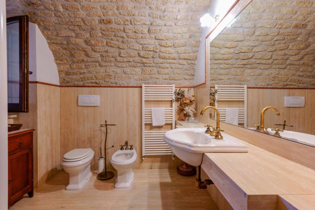 une salle de bain avec un lavabo et des toilettes dans l'établissement tHE Italian Dream Villa - Pool, Spa & Wine, à Boceto