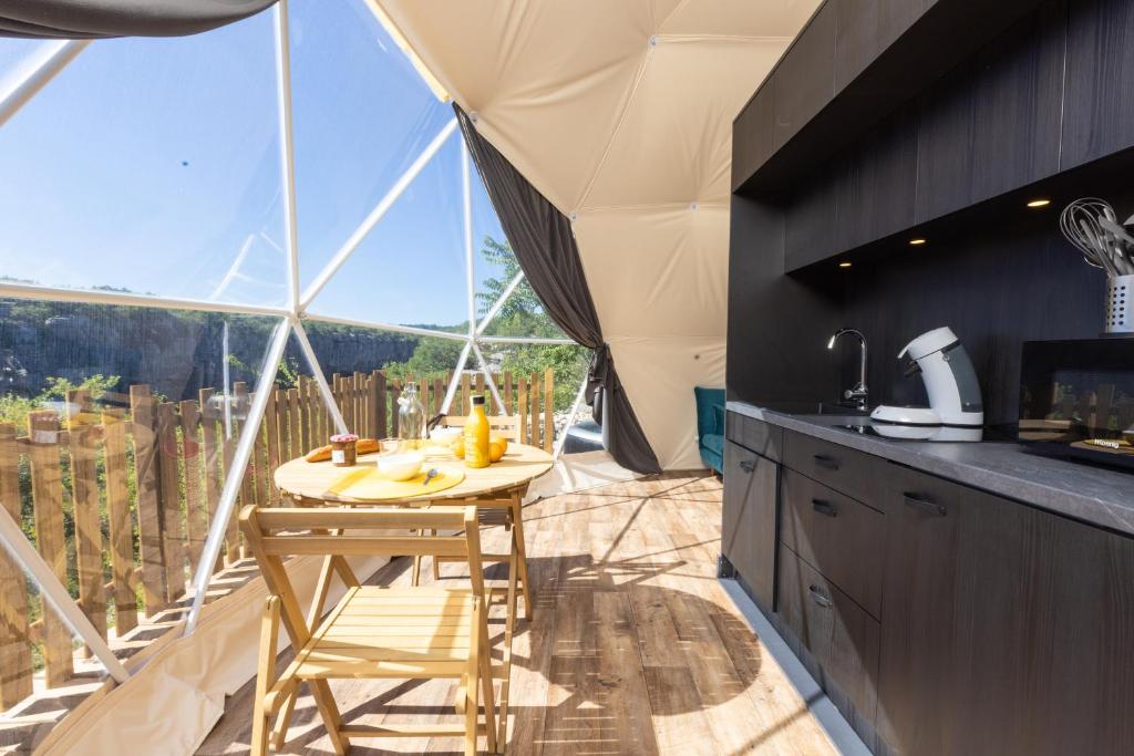 une cuisine avec une table et une grande fenêtre dans l'établissement Les Dômes des Gorges, à Ruoms
