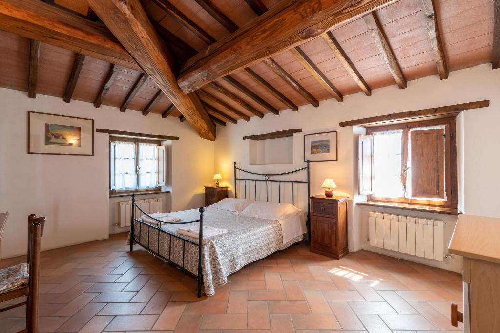 une chambre avec un lit dans une pièce avec des plafonds en bois dans l'établissement Villa Agriturismo Cuiano - Pierle, à Cortone