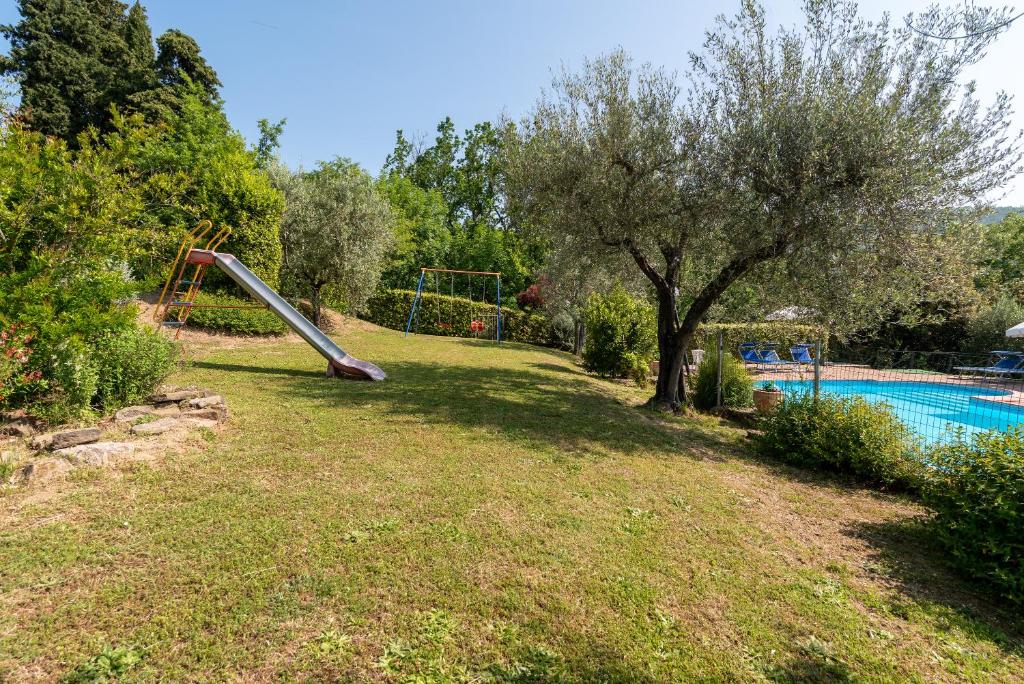 - un toboggan dans une cour à côté d'une piscine dans l'établissement Villa Agriturismo Cuiano - Pierle, à Cortone