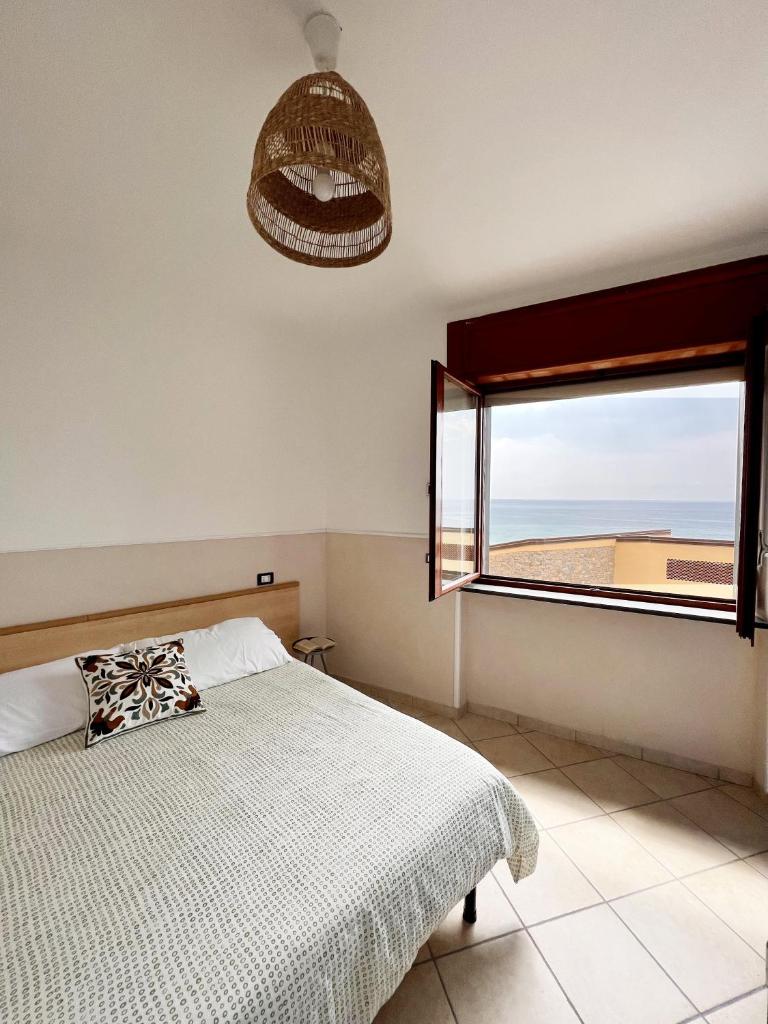 une chambre avec un lit et une grande fenêtre dans l'établissement Residenza Fontanelle-Beach Resort, à Santa Maria di Castellabate