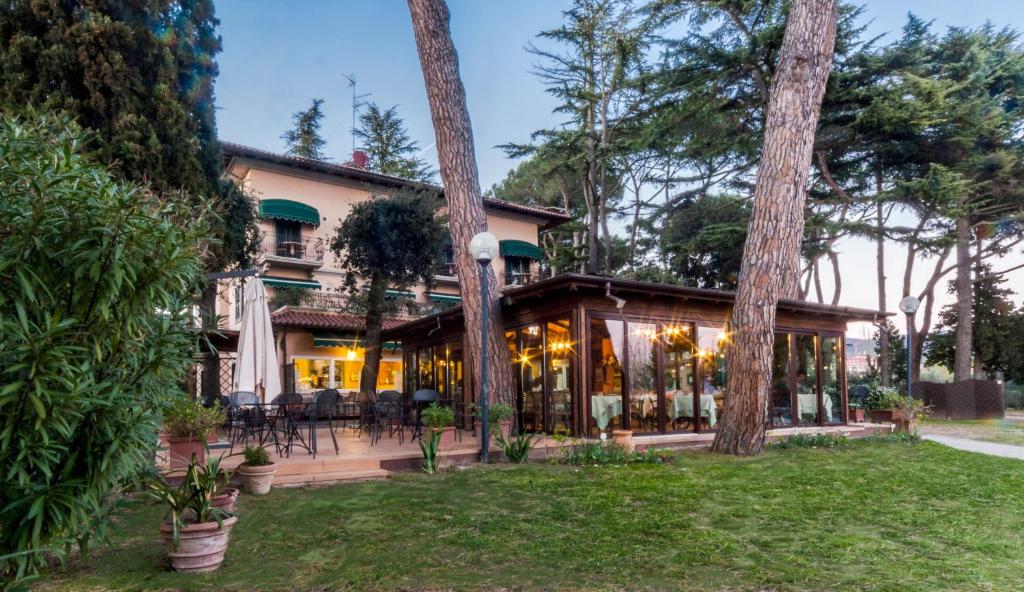 une vue extérieure d'une maison avec des arbres dans l'établissement Hotel Kursaal, à Passignano sul Trasimeno